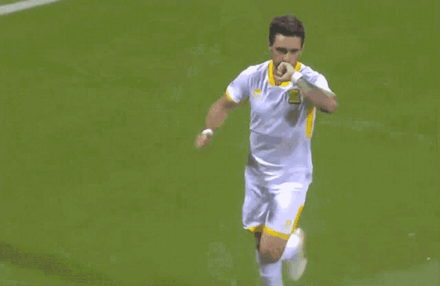 a soccer player in a white and yellow uniform with the number 10 on the shorts