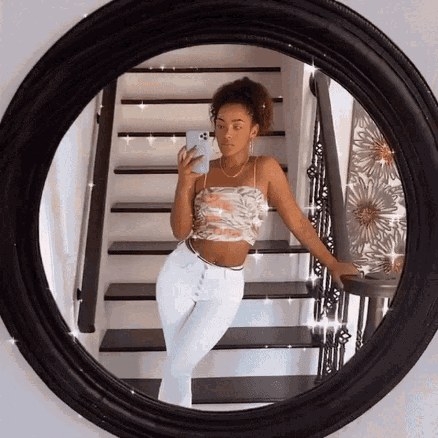 a woman is taking a picture of herself in a round mirror