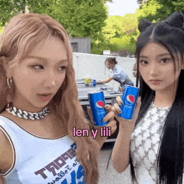 two girls are holding pepsi cans and one has the word len y lili on her shirt