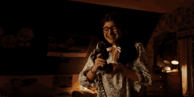 a girl with glasses is talking on a phone