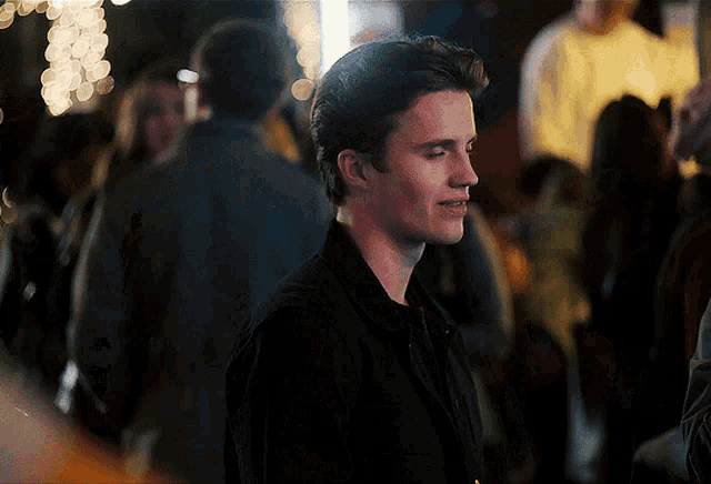 a man in a black shirt is standing in a crowd of people
