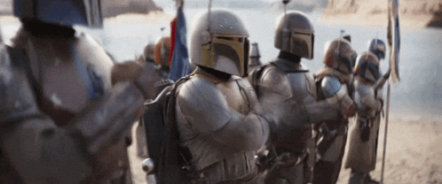 a group of soldiers wearing helmets are standing in a line .