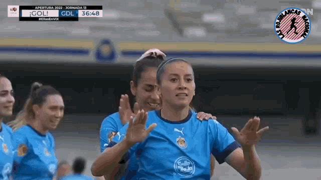 a group of female soccer players celebrate a goal with a score of 36 48