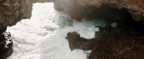 a cave with waves crashing into the rocks