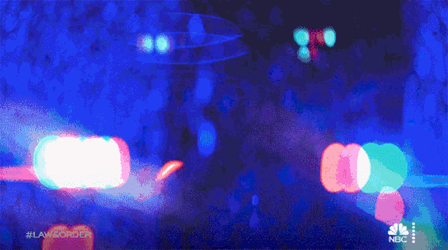 a blurry picture of a police car with the words law & order on the bottom right