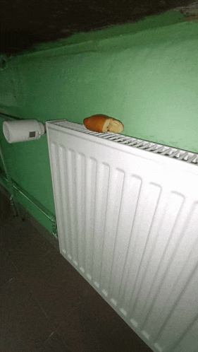 a piece of bread is sticking out of a white radiator