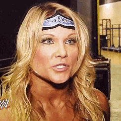 a blonde woman wearing a headband with a crown on her head