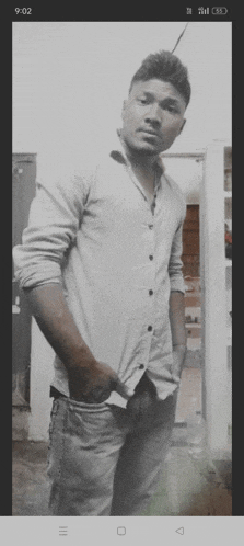 a black and white photo of a man with his hands in his pockets and the time of 9:02