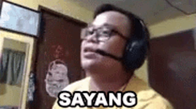 a man wearing headphones and glasses is making a funny face while talking on a video call .