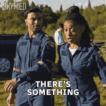 a man and a woman are walking in a field with the words there 's something written on the bottom