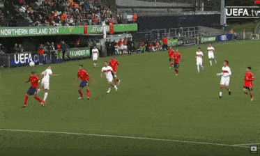 a group of soccer players are playing on a field with a sign that says uefa