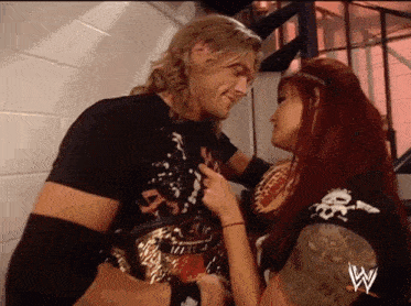 a man and a woman are standing next to each other with a w logo on the bottom