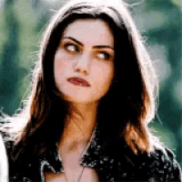 a woman with long dark hair is wearing a black shirt and a necklace