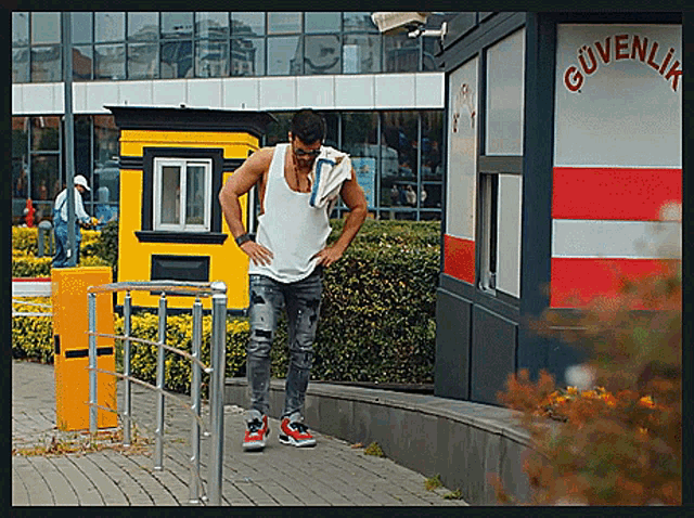 a man standing in front of a building that has the word güvenlik on it