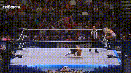a wrestling match is being played in a ring with a crowd watching .