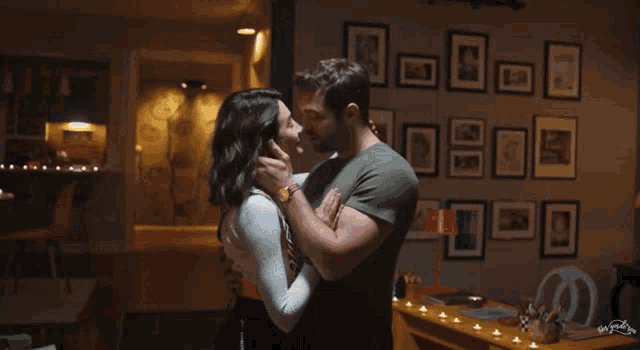 a man and a woman are kissing in a living room