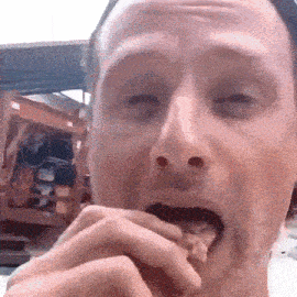 a close up of a man 's face eating something