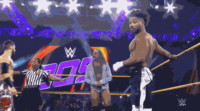 wrestlers in a wrestling ring with a w logo in the back