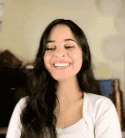 a woman with long hair is smiling with her eyes closed .