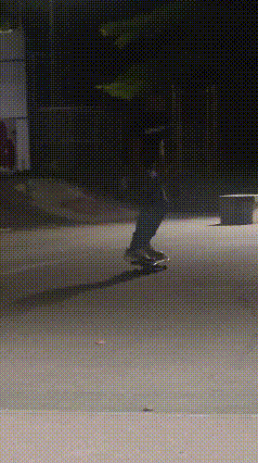 a person is riding a skateboard down a street at night