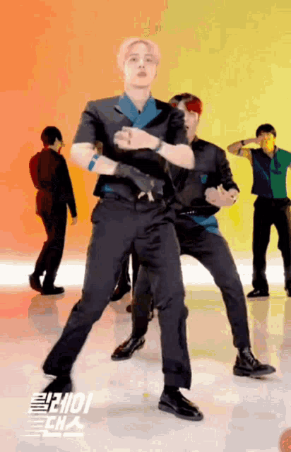 a group of men are dancing in front of a sign that says ' ioiioi ' on it