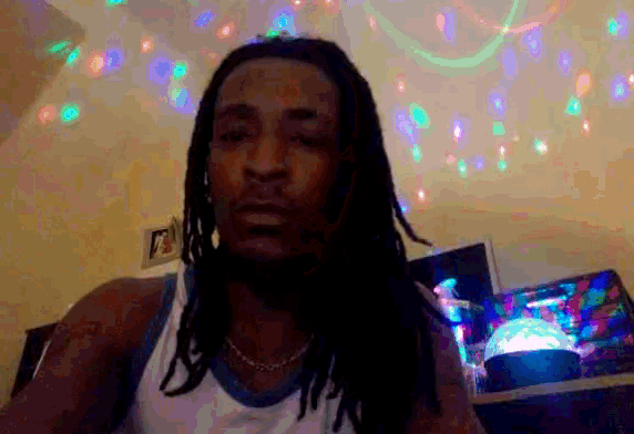 a man with dreadlocks is standing in front of a wall of lights