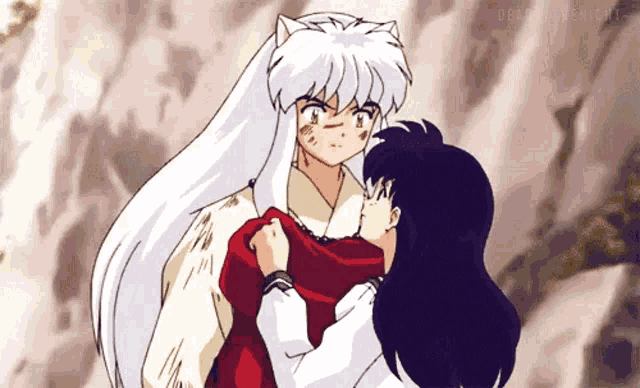 inuyasha is holding a girl in his arms and they are hugging each other .