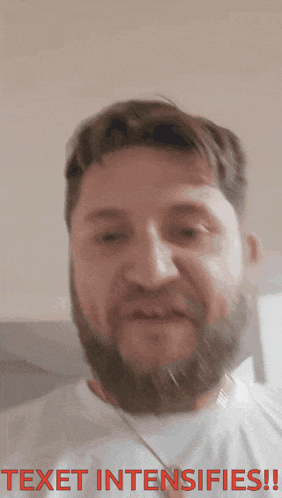 a man with a beard is wearing a white shirt with the words " texet intensifies " on the bottom