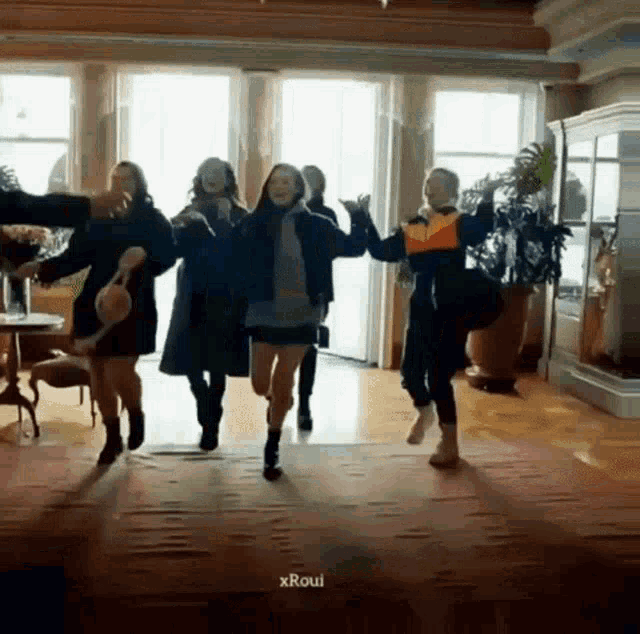 a group of people are dancing together in a room .