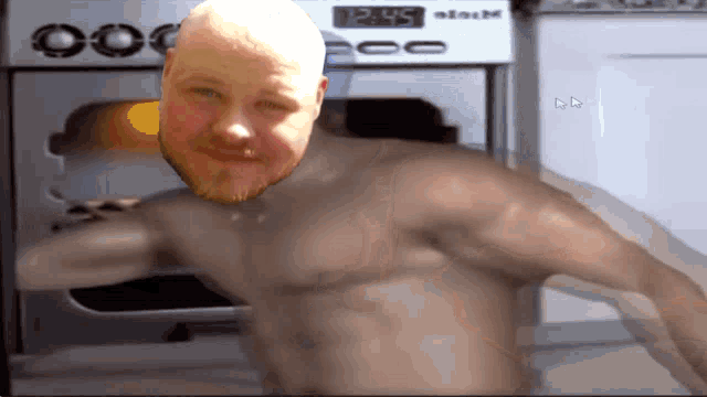 a shirtless man stands in front of a kitchenaid stove