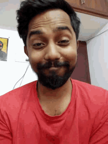 a man with a beard and a red shirt is smiling