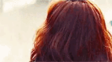 the back of a woman 's head with red hair