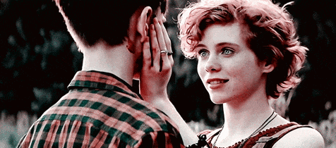 a man and a woman are looking at each other and the woman is wearing a ring on her finger .
