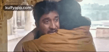 a man and a woman are hugging each other in a temple .