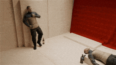 a man leaning against a wall next to a bottle of alcohol and a man laying on the floor