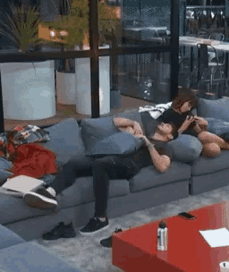 a man and a woman are laying on a couch