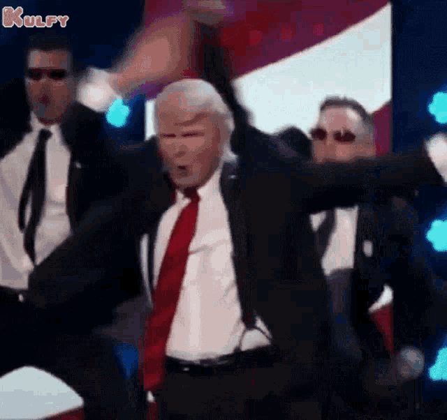 a man in a suit and tie is dancing with a group of men .