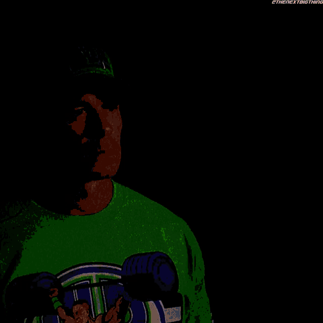 a man wearing a green shirt and a green hat is talking to another man