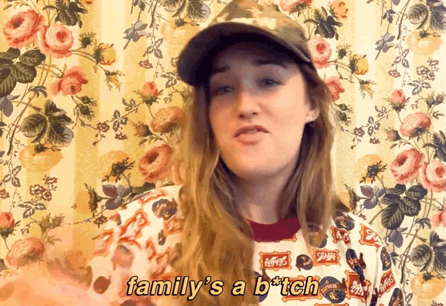 a woman wearing a hat and a sweater says family 's a b * tch