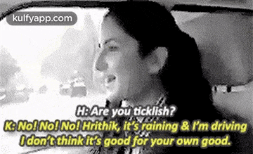 a woman is sitting in the driver 's seat of a car talking to another woman .