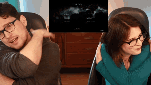 a man and a woman are sitting in front of a screen that says " the party "