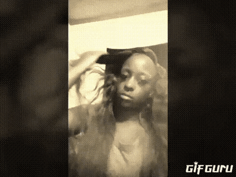 a woman is sitting on a bed with her hair in a ponytail .