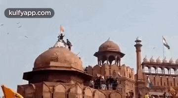 a group of people are standing on top of a very tall building .