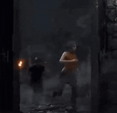 a man and a woman are standing next to each other in a dark room . the woman is naked .