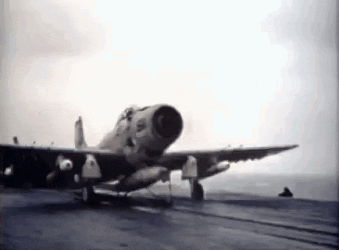 a fighter jet is sitting on top of an aircraft carrier .