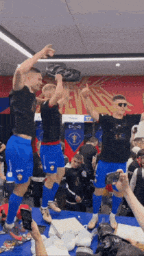 a group of soccer players are celebrating with a trophy