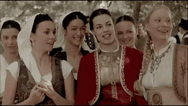 a group of women are posing for a picture and smiling for the camera .