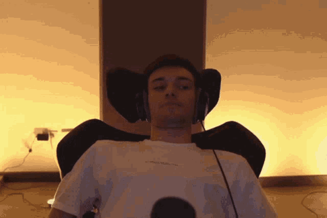 a man wearing headphones sits in a chair