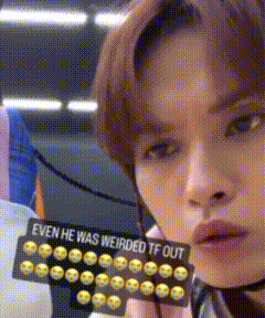a young man is holding a sign that says `` even he was weirded tf out '' .