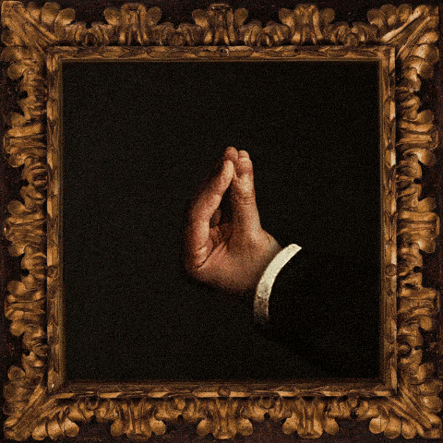a framed painting of a man 's hand with a gold frame